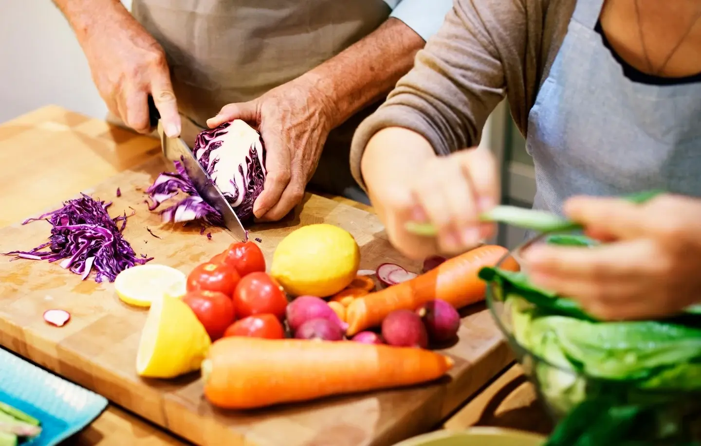 Older couple cooks healthy food together in their kitchen.